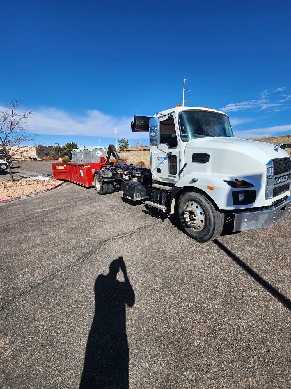 Bigfoot Portables roll off truck with a dumpster in a commercial lot